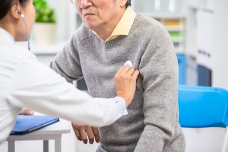 Female doctor uses a stethoscope to examine an elderly paient's heartbeat