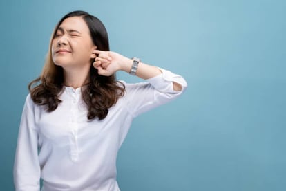 Woman putting a finger into her ear
