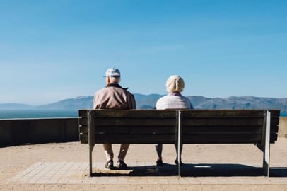 older couple sitting on a bench 
