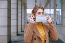 woman putting on a face mask